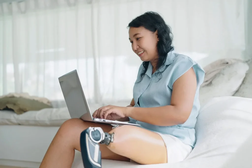 Woman with disability using laptop at home