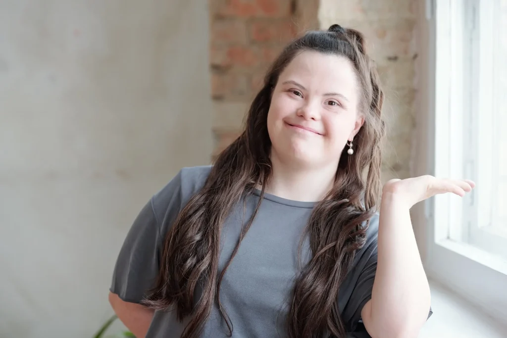 Woman with Down syndrome smiling and gesturing indoors