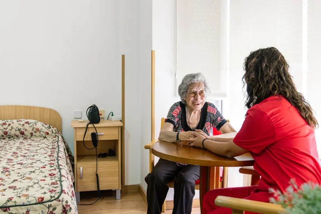 Carer holding hands with smiling elderly woman